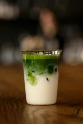 Iced matcha Latte ve sklenici na stole